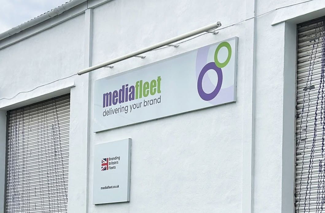 MediaFleet white building facade in Witney, with its full sign and roller shutters