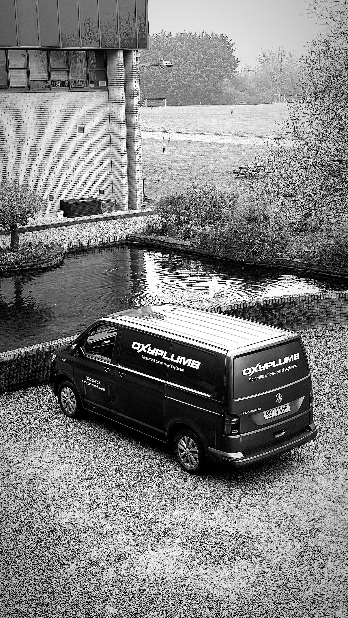 Oxyplumb-branded Volkswagen van parked beside a building