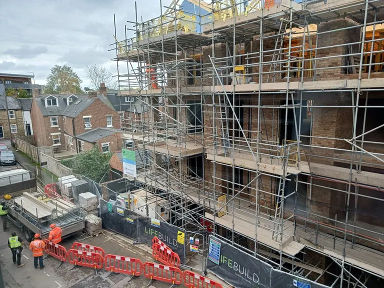 Scaffolding around a brick apartment building under construction in Oxford.