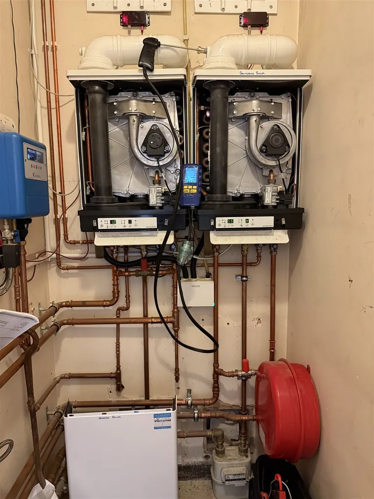 Oxyplumb servicing and testing existing twin boilers with a flue probe and combustion analyser