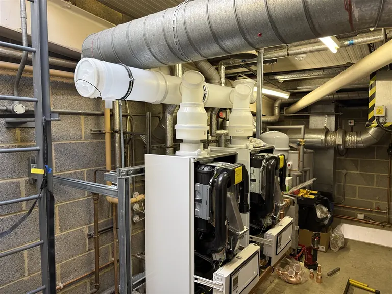 Twin Vaillant commercial boilers on the custom cascade frame with the new flue under construction
