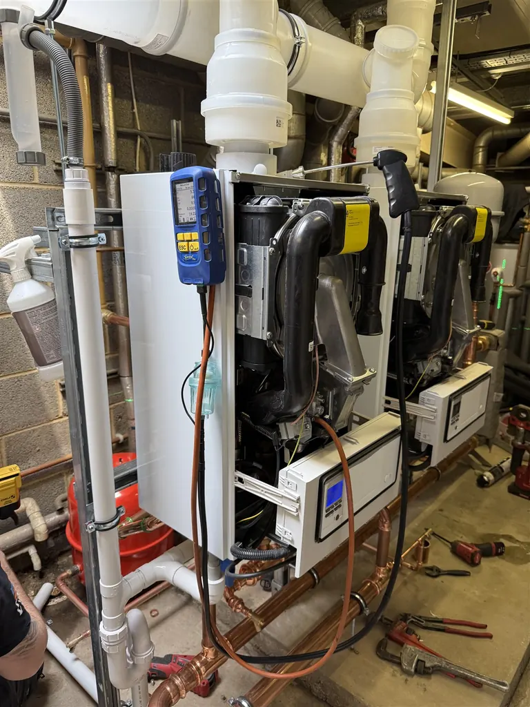 Combustion analyser connected to the open Vaillant commercial boiler cascade during testing