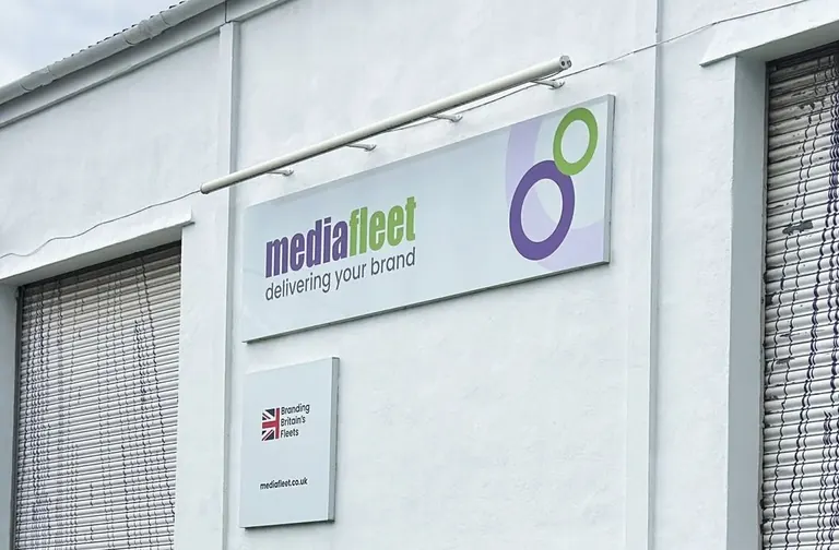 MediaFleet white building facade in Witney, with its full sign and roller shutters