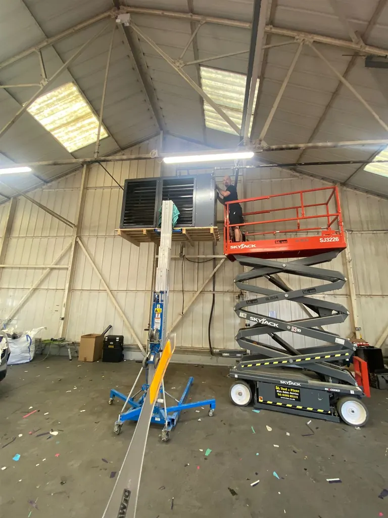 Powrmatic warehouse heater being raised onto its new Unistrut support frame