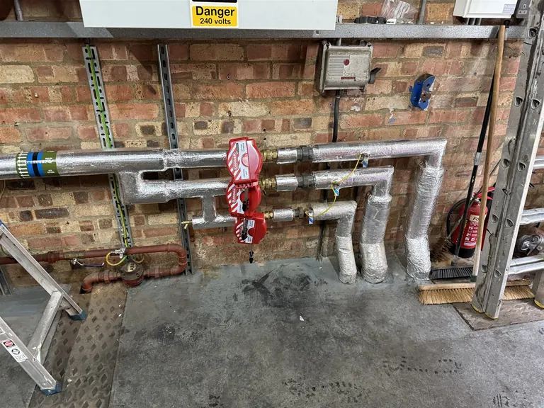 Insulated heating distribution pipework valves and service labels at Mulberry Bush School