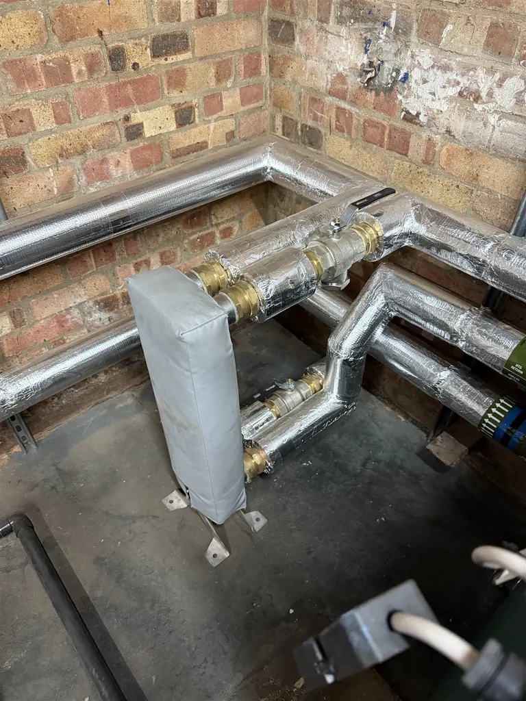 Low-level headers with silver-foil insulation and service labels