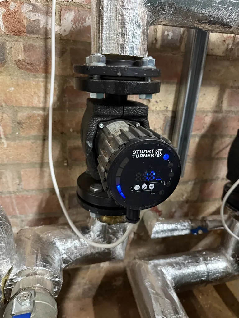 Close view of a Stuart Turner pump and insulated heating pipework