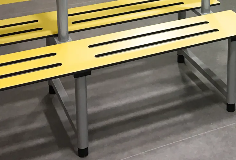 Yellow slatted Venesta changing-room bench with metal supports