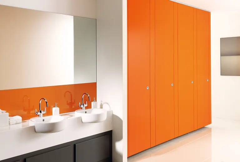 Orange Venesta Unity toilet cubicles beside a row of washbasins