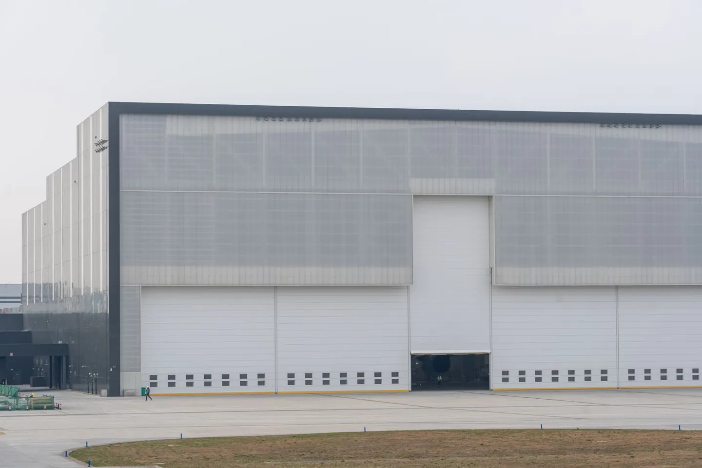 Large silver-clad industrial building with tall loading doors.