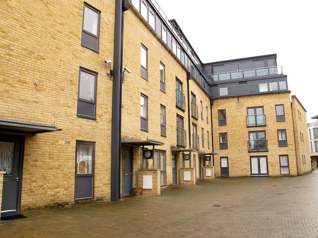 Modern brick apartment buildings around a paved courtyard in Oxford.
