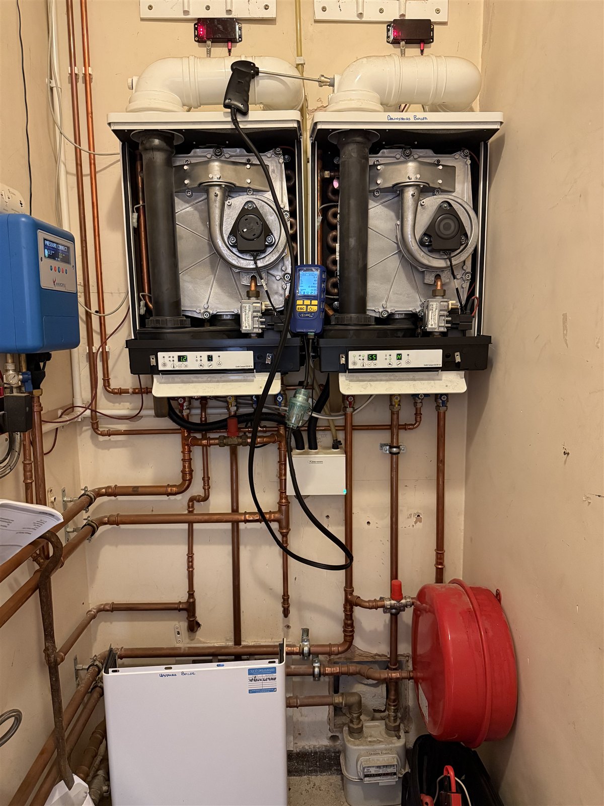 Oxyplumb servicing and testing existing twin boilers with a flue probe and combustion analyser